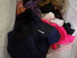 a pile of clothes in a bag on a bed