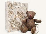 a teddy bear sitting next to a gift bag