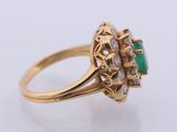 a close up of a gold ring with a green stone