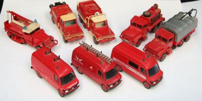 beaucoup de petits camions de pompiers rouges en plastique posés sur une table