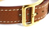 a close up of a brown leather bracelet with a gold buckle