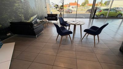 trois chaises et une table dans le hall d'un immeuble