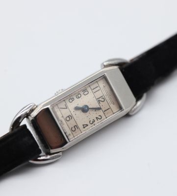 a silver watch with a black strap on a white surface