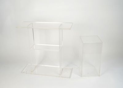 two clear acrylic stands on a white surface with a white background