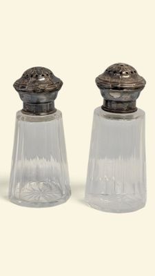 two salt and pepper shakers sitting next to each other