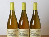 trois bouteilles de vin posées sur une table en bois