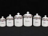 six white ceramic canisters with blue and white designs on them