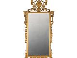 an image of a gold framed mirror with a bird on it
