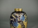 vase with blue and yellow flowers on it on a gray surface