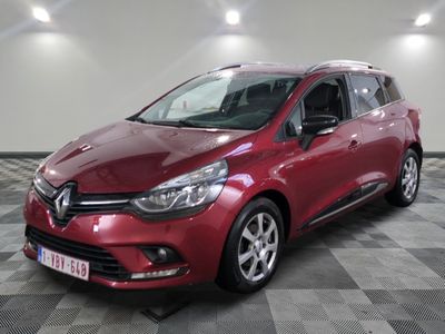 a red car is parked on a checkered floor in a garage