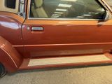 an orange car parked in a garage with its door open