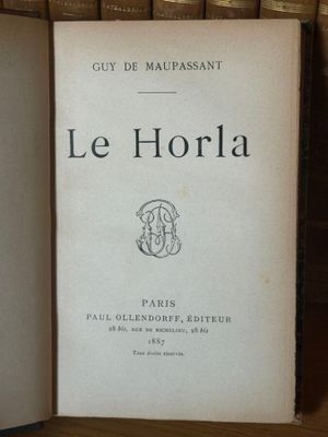 un livre posé sur une étagère à côté d'une pile de livres