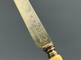 an image of a knife with a carved handle on a gray surface