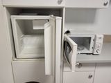 a microwave that is open in the corner of a kitchen