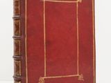 un vieux livre en cuir rouge, avec des bordures dorées et une encadrement doré