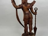 an image of a wooden statue of a man holding a staff