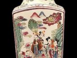 a vase with a painting on it sitting on a table