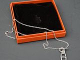 une boîte orange à laquelle est attachée une chaîne argentée