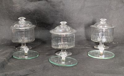 trois bocaux en verre avec leurs couvercles, posés sur une table
