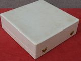 une petite boîte blanche posée sur une table rouge