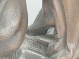 a bronze statue of a woman sitting on a bench