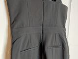a close up of a pair of grey overalls hanging on a hanger