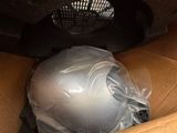 a silver helmet in a box with a plastic cover