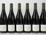 six bottles of wine are lined up in a row on a table