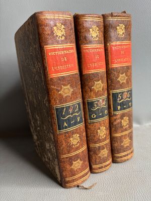 three old books sitting on top of each other on a table