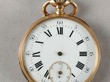 a gold pocket watch with roman numerals on the face