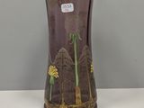un vase violet orné de fleurs jaunes, posé sur une table