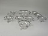 a group of glass bowls with silver rims sitting on a white surface