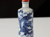a small blue and white bottle with a dragon on it