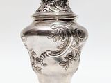 une image représentant un vase en argent surmonté d'un oiseau