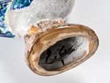 a vase with a bird on it sitting on a table