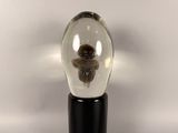 a snow globe with a bear in it on a black stand