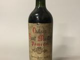une bouteille de vin rouge posée sur une table blanche