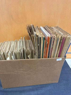 une boîte en carton remplie de vieux disques posée sur une table