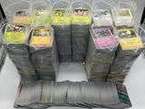 Plusieurs paquets de cartes à collectionner Pokémon sont empilés les uns sur les autres.