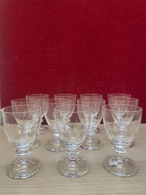 several empty wine glasses sitting on a table in front of a red wall