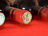 several bottles of wine are lined up on a red table