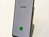 the back of a black phone with a green button on it