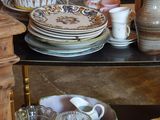 many plates and cups on a shelf in a room
