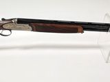 un gros plan d'un fusil posé sur un support transparent, sur une surface blanche