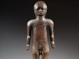 une statue en bronze représentant un homme debout sur un socle noir
