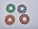 four different colors of bottle caps on a white surface