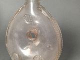 a glass bottle with a hole in it on a table