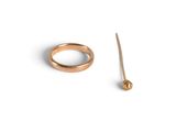 a gold ring and a stick on a white surface