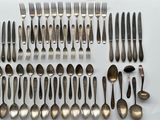 a group of silverware including forks and spoons on a white surface