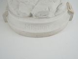 a statue of a man sitting on top of a white pedestal